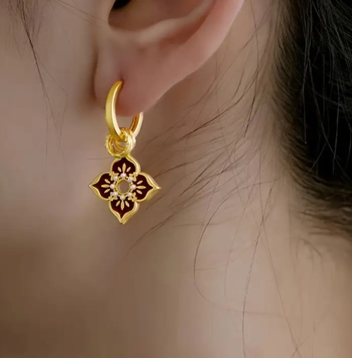 Woman wearing elegant vintage-inspired colorful enamel hoop earrings, daily look
