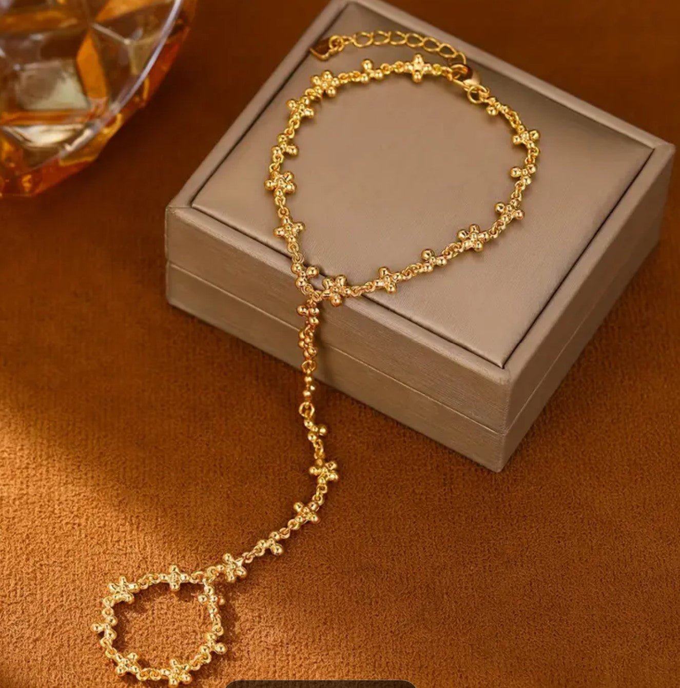 Close up of intricate golden petal design on 14K gold plated Bohemian hand chain bracelet