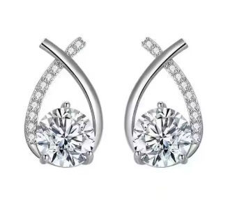 Close up of sparkling crystal, delicate cross, and fishtail design on stud earrings