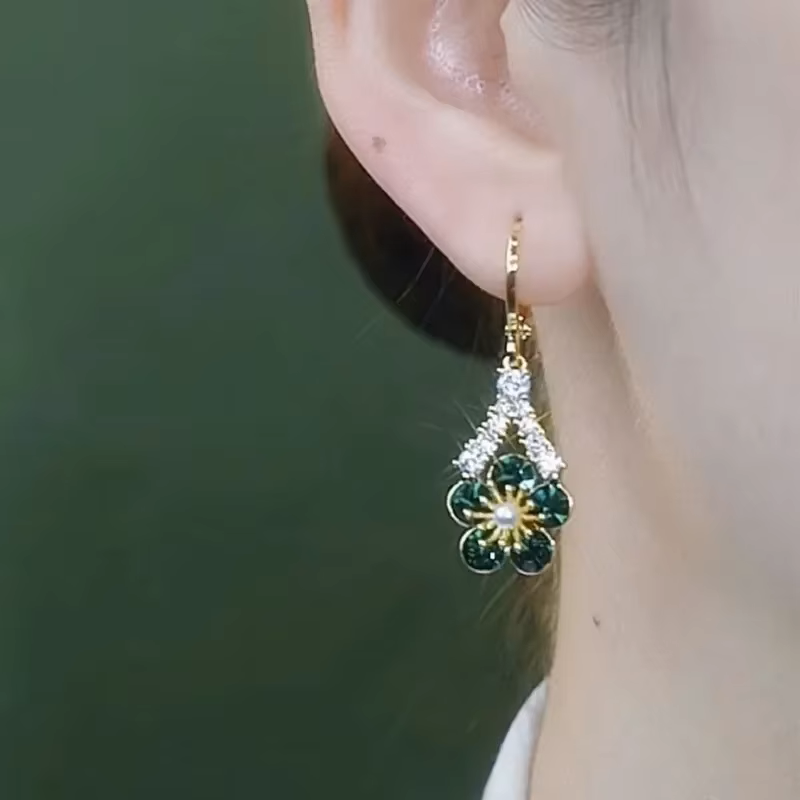 Woman wearing Alam Ara dangle green white zircon earrings, showing elegant style