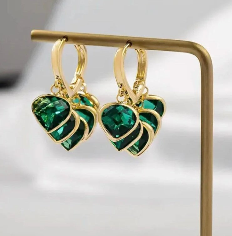 Close up of sparkling green crystals on golden hoop earrings design
