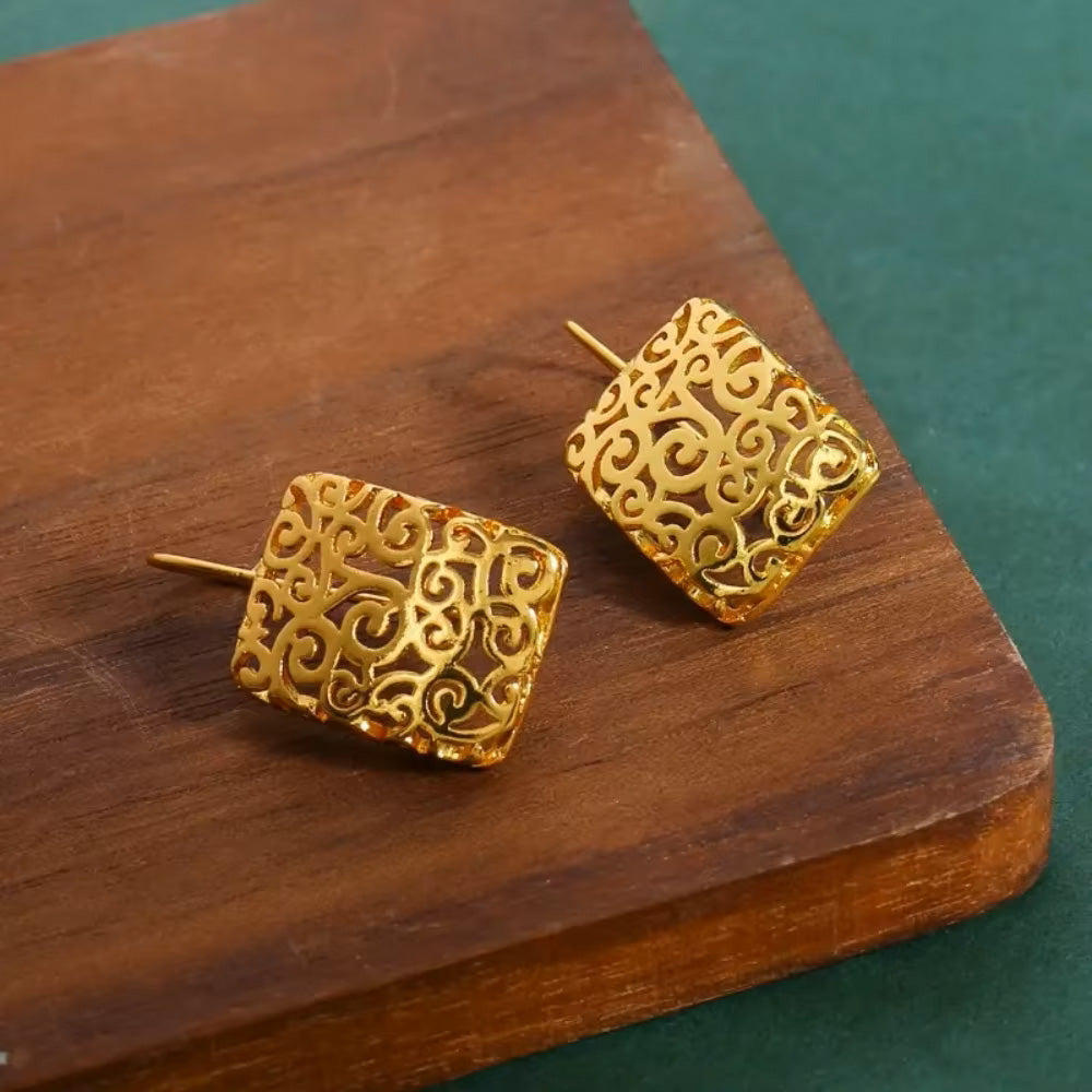 Close up of intricate hollow filigree design on 14K gold plated drop earrings