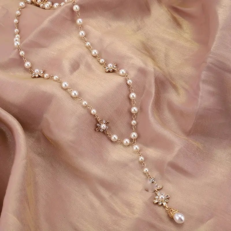 Close up of luminous imitation pearls and artificial gemstones on long pendant necklace