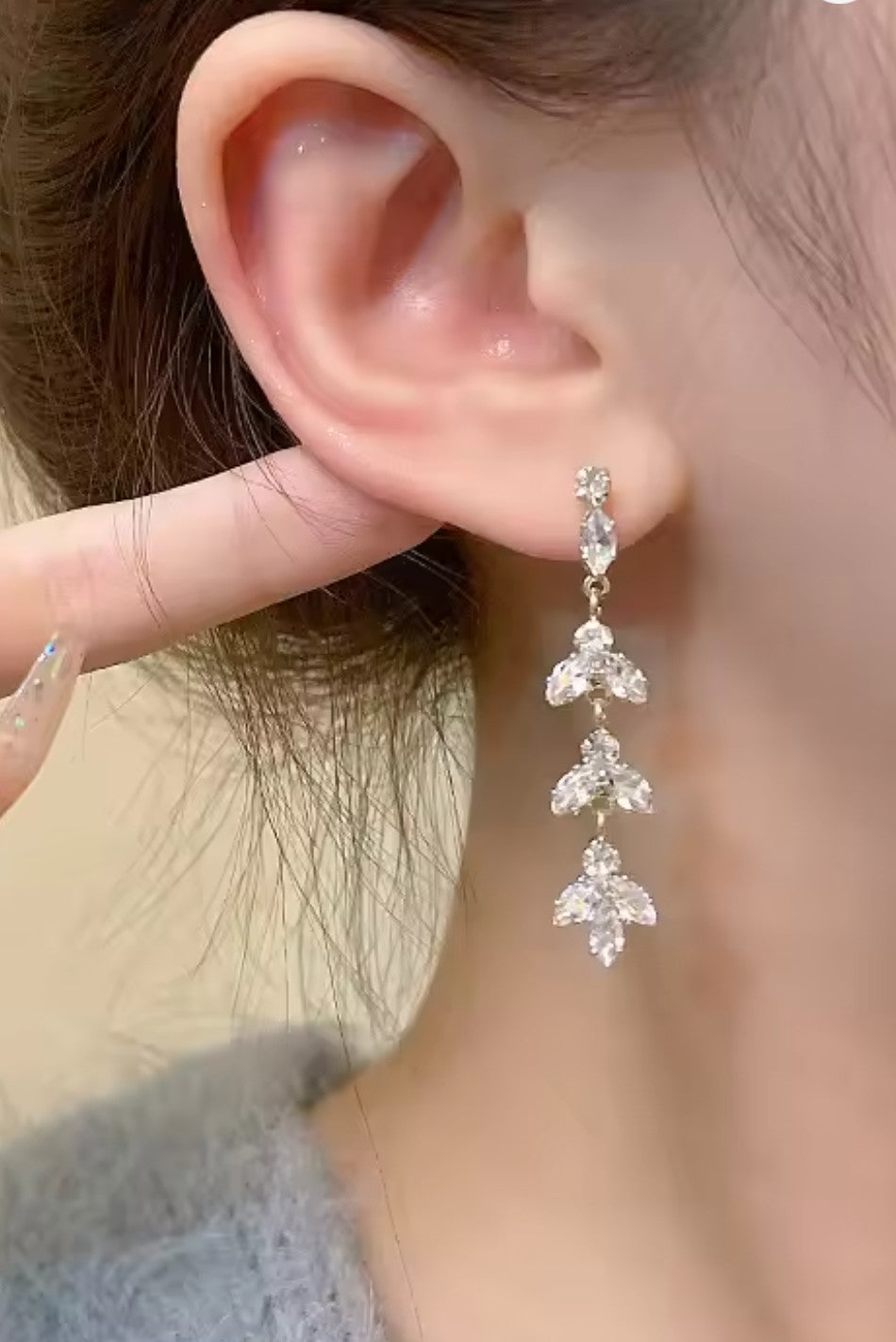 Woman wearing exquisite zirconia leaf tassel drop earrings, showing intricate detail