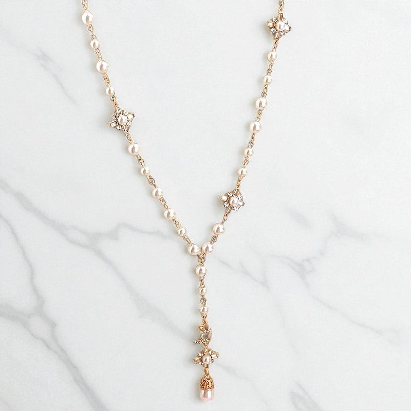 Side view of elegant long imitation pearl pendant necklace, showing copper chain